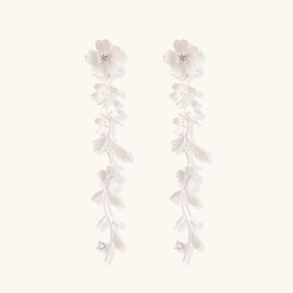 Long sterling silver drop earrings with delicate floral vine design and crystal accents on white background